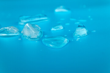 Fototapeta premium Ice melts against a blue background.