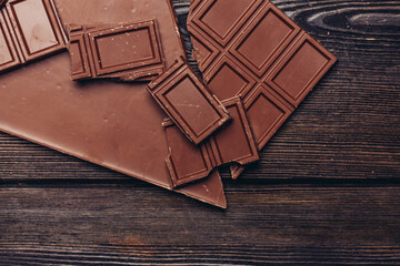 delicacy of sweet chocolate on wooden background top view texture