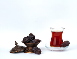 A cup of tea with dates on a plate isolated