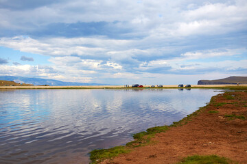 View of the lake on a cloudy summer day. Beautiful sky with clouds. A popular tourist destination. 