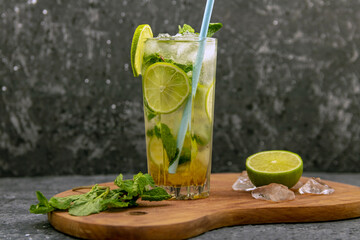 Mojito cocktail drink with lime and mint on dark background with copy space