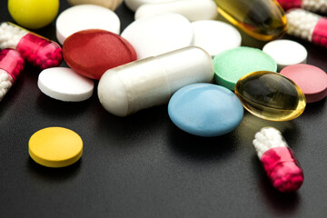 Multicolored tablets on black background. Health care concept.