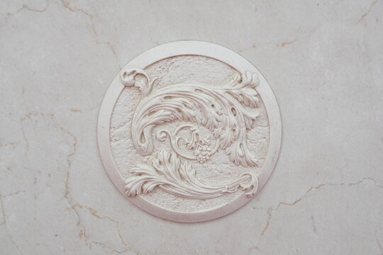 Close-up of a decorative element of the interior of the room - white plaster moldings on white marble. Can be used as background