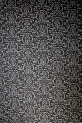 Close-up of a decorative element of the interior of the room - wallpaper in black (dark) color with a pattern of gray. Can be used as background