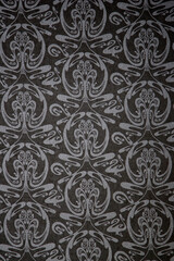 Close-up decorative element of the interior - black (dark) wallpaper with (white or gray) pattern. Can be used as background