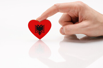 Albania flag. Love and respect Albania. A man's hand holds a heart in the shape of the flag of...