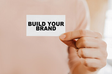 Man holding a business card with Build Your Brand