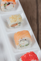 Salmon rolls in a white platter with mixed ingredients