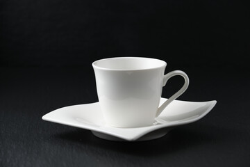 Empty white cup of coffee on black background
