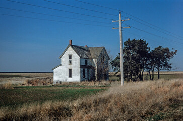 Abandoned farmhouse in Nebraska USA. Rural life. Impoverishment. Lonely wooden house at the prairie.