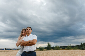 Lovers on the wheat field at the dark sky background