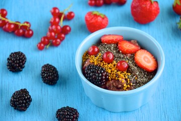 Chocolate oatmeal porridge with strawberry, blackberry, red currant, hemp seeds and flax seeds
