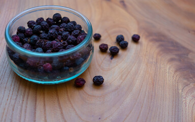 Dried fruits: wild rose, hawthorn in a glass jar on a wooden table-medicinal useful berries