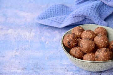 Homemade healthy energy balls with chocolate, raisin, quinoa and oat on blue background
