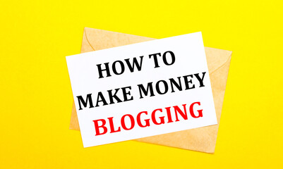 On a yellow background, an envelope and a card with the text HOW TO MAKE MONEY BLOGGING. View from above