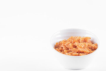 Fototapeta na wymiar Bowl of raw heart shaped pasta on white background