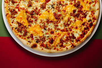Top view pizza with mushrooms and tomatoes on a green-red background
