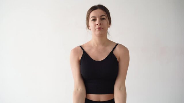 Beautiful sexy girl at home works out with dumbbells. Exercise for the muscles of the arm. white wall.