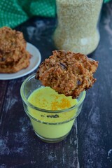 Golden milk drink with quinoa chocolate cookies on wooden background