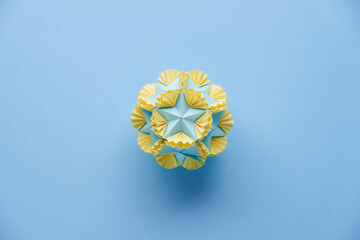 Multicolor handmade modular origami ball or Kusudama Isolated on blue background. Visual art,...
