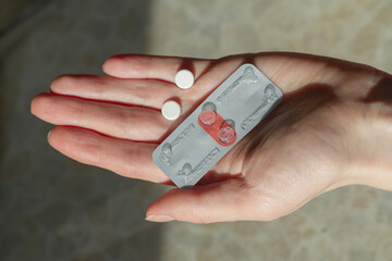 Two pills for emergency contraception on the hand of a woman