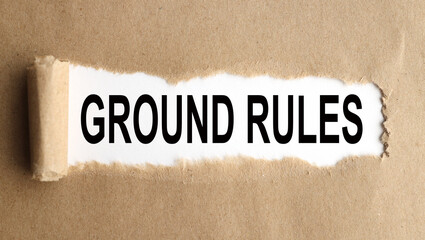 ground rule. text on white paper over torn paper background.