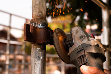 The old man working from Steel grinding machine  , it has fire affect and so noisy