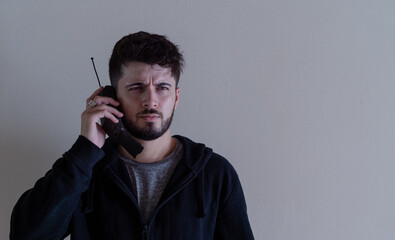 Handsome young man making a call from an old cell phone