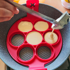 Pancake in cottura in padella con l'utilizzo di un supporto di silicone per dargli la forma