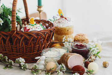 Stylish easter eggs, homemade Easter bread, traditional Easter food in  basket on rustic table