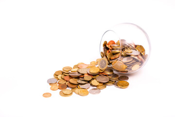 Glass jar with scattered coins on a light background. Accumulation and investment with increasing income. Save money on training in the future. Contribution to the future.