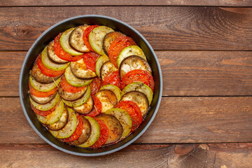 Vegetable ratatouille in frying pan on a wooden table