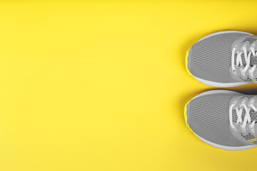 Gray sneakers on a yellow background sport concept, free space.