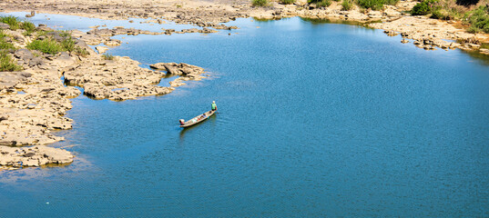Obraz premium The atmosphere along the river, clear water, rocks and fishermen looking for fish in the river.