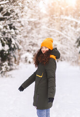 Fototapeta na wymiar Beautiful girl walks in the winter forest on a sunny day