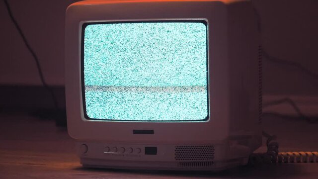 Old CRT TV on the ground with noise interference. Red background with camera movement