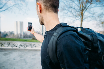 Young caucasian sportive man outdoor using smartphone taking selfie