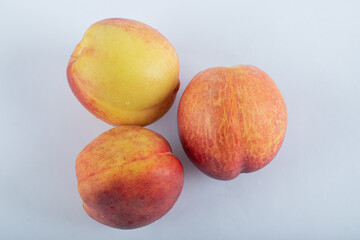 Three fresh nectarines on a white background