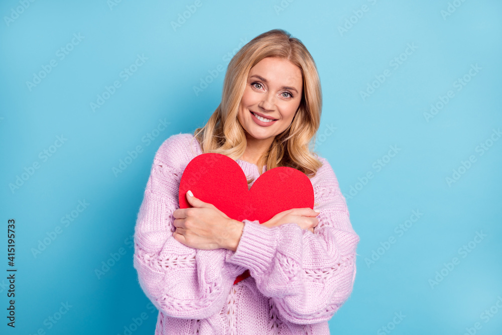 Poster photo portrait of blonde woman smiling embracing heart love symbol in pink sweater isolated bright b