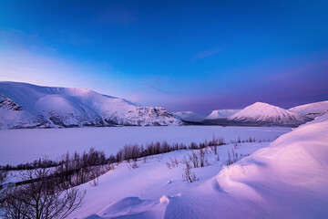 Evening sunset in the snow-capped mountains in lilac color