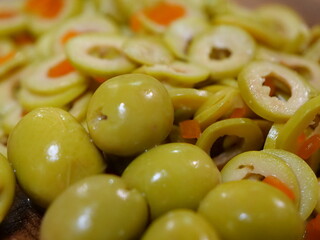 Ganze und in Scheiben geschnittene mit Paprika gefüllte grüne Oliven