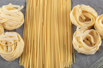 still life: spaghetti, black pasta, flour on the wooden table