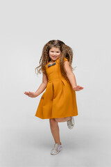 Jumping high. Happy, smiley little caucasian girl isolated on white studio background with copyspace for ad. Looks happy, cheerful. Childhood, education, human emotions, facial expression concept.