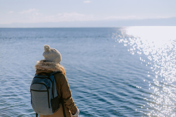 Fototapeta premium Woman looking at sunset over a lake