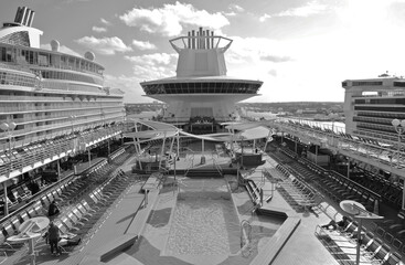 Outdoor pool deck with sun loungers and deck chairs on modern cruiseship or cruise ship liner in...