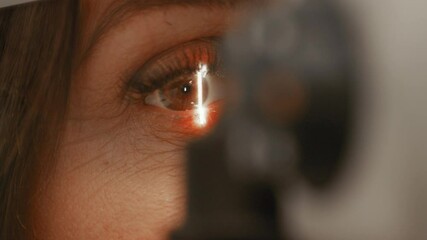 Close up of microscope bright light optician optometrist looking at pupils at eye clinic searching for damaged and faulty problems need surgery contact lenses short sighted eyes laser medical frame