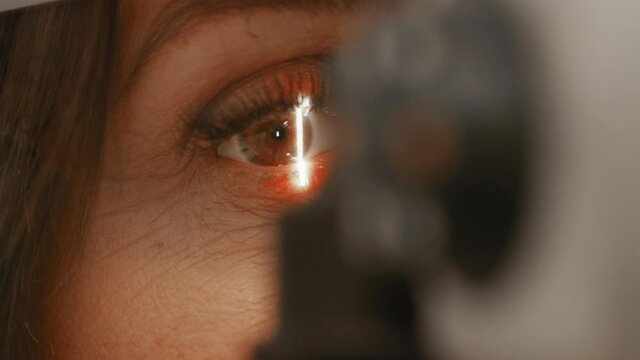 Close up of microscope bright light optician optometrist looking at pupils at eye clinic searching for damaged and faulty problems need surgery contact lenses short sighted eyes laser medical frame