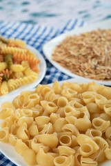 Variety of dry pasta on white plates