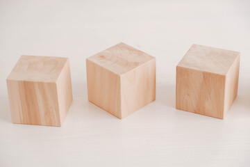 Three wooden blocks from natural wood on a white background. Copy, empty space for text