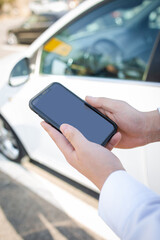 smartphone in male hands on the background of the car